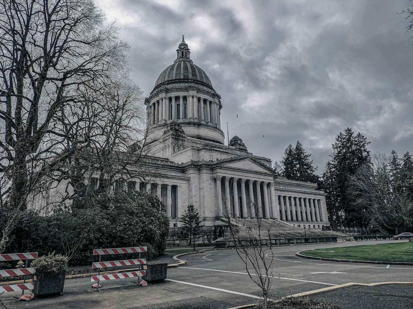 Classical government building with dome and columns under grey sky.